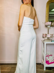 White strapless flared leg jumpsuit with ruffle overlay on bodice, fully lined.