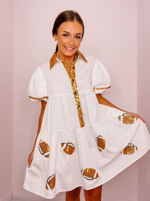 White poplin gold sequined tiered shirt dress with gold piping and footballs, side pockets. 
