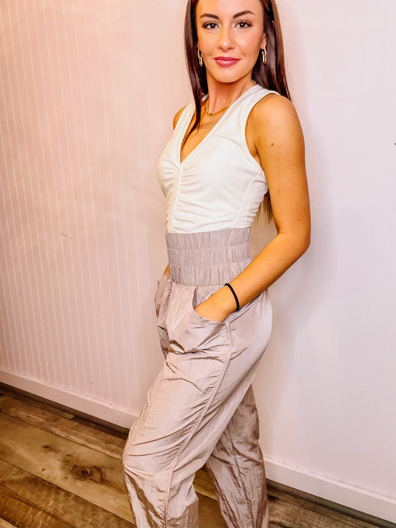 Dusty rose smocked waistband nylon jogger pants with patched pocket.