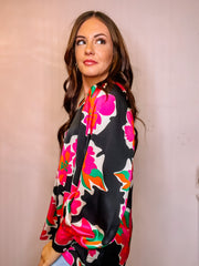 Black satin floral print v-neck long sleeve top featuring pleated detail along neckline. Extended sleeve cuffs. 