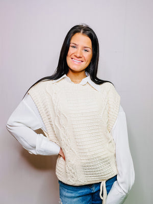 Mystree, Inc. Ivory drop shoulder cable knit vest with waist drawstring. Sleeveless with drop arm hole.